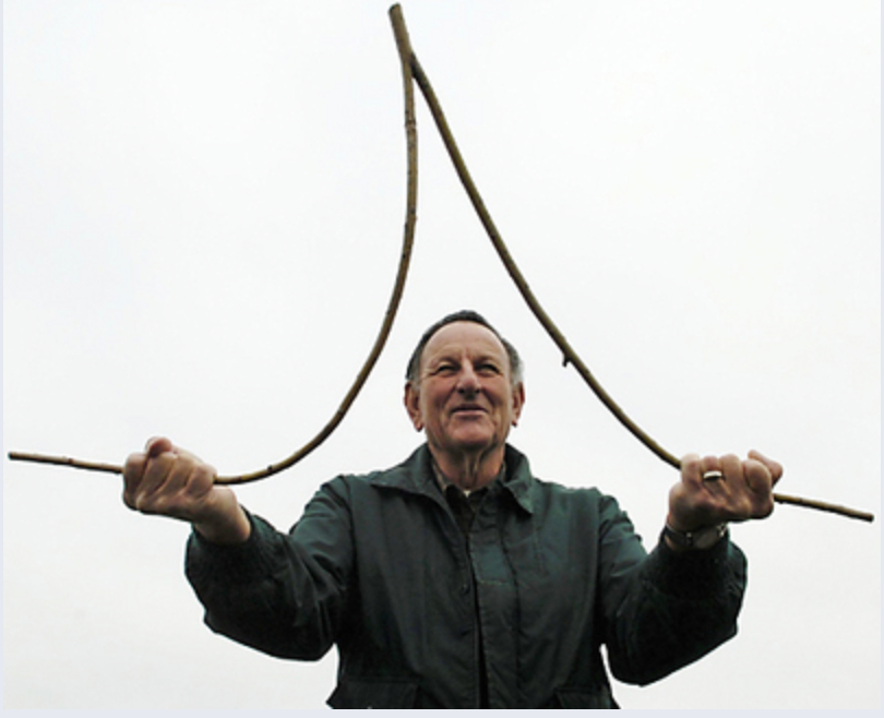 A man dowsing with a traditional Y-rod